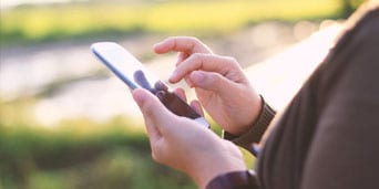 A person texting with the phone on his hand